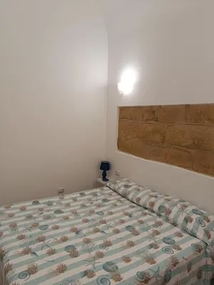 a bedroom with a bed and a light on the wall at Casa Atlanna in Terrasini