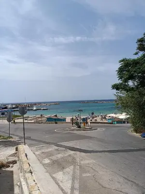 an empty street next to a beach with the ocean at Casa Atlanna in Terrasini