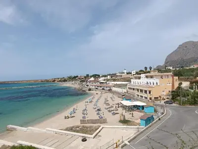 a beach with a bunch of chairs and the ocean at Casa Atlanna in Terrasini