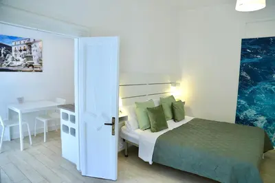 a bedroom with a bed with green pillows and a table at Cara Palermo in Palermo
