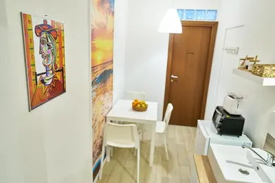 a small kitchen with a white table and a sink at Cara Palermo in Palermo