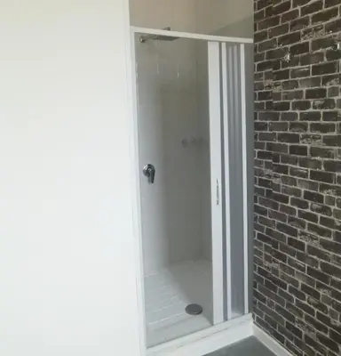 a shower in a bathroom with a brick wall at Villa Aurora Appartamento in villa con piscina in Bagheria