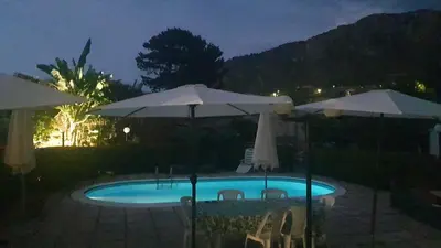 a swimming pool with umbrellas and chairs at Villa Aurora Appartamento in villa con piscina in Bagheria