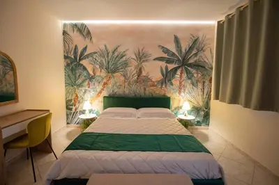 a bedroom with a bed and a mural of palm trees at RelaxTime Casa Vacanze in Palermo