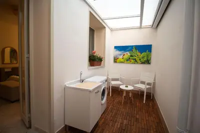 a bathroom with a washing machine and a table and chairs at RelaxTime Casa Vacanze in Palermo