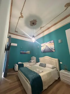 a bedroom with a bed and a blue wall at Emanuela Home in Palermo