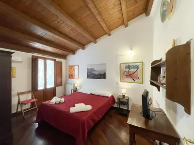a bedroom with a red bed with two towels on it at House Quattro Canti in Palermo