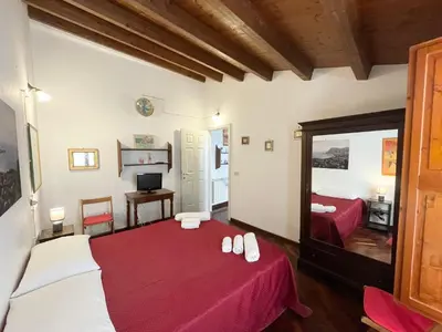 a bedroom with a red bed and a mirror at House Quattro Canti in Palermo
