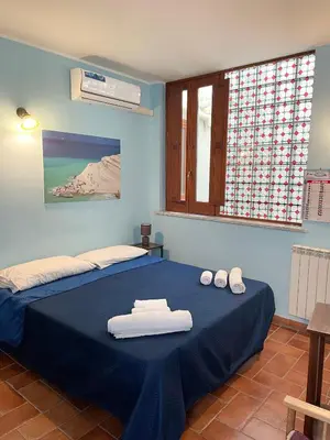 a blue bedroom with a bed with towels on it at House Quattro Canti in Palermo