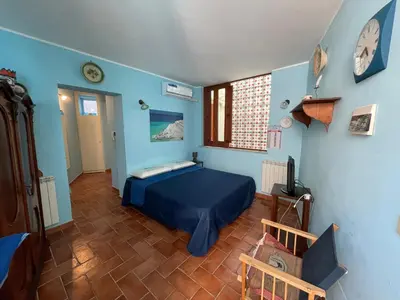 a bedroom with a bed in a blue room at House Quattro Canti in Palermo