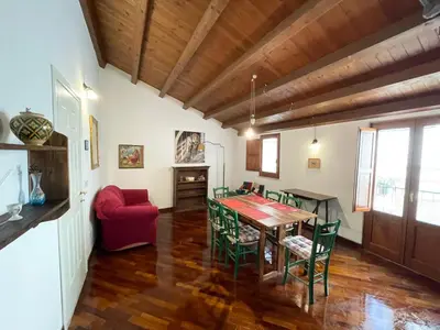 a dining room with a table and green chairs at House Quattro Canti in Palermo