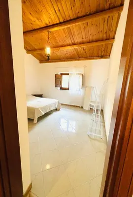 a bedroom with a bed and a table and chairs at Villetta Verde Mare - Scopello in Scopello