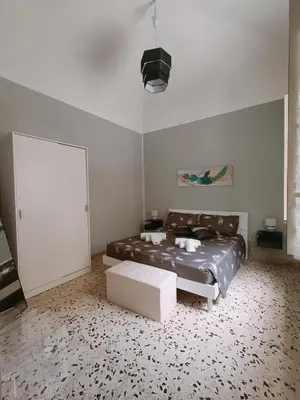 a bedroom with a bed and a couch and a table at Gioiello di casa in Palermo
