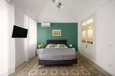 a bedroom with a bed and a large window at La Castellana Apartments, vista panoramica sul mare, nel cuore storico di Carini, a due passi dal Duomo e dal castello in Carini