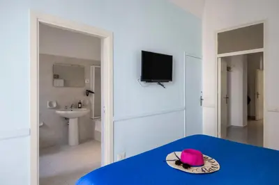a pink hat sitting on a blue table in a bathroom at La Castellana Apartments, vista panoramica sul mare, nel cuore storico di Carini, a due passi dal Duomo e dal castello in Carini