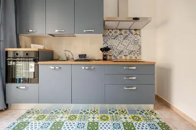 a kitchen with gray cabinets and a tile floor at AL Qanat di Notarbartolo in Palermo