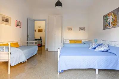 two beds in a room with blue and yellow pillows at AL Qanat di Notarbartolo in Palermo