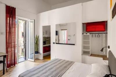 a white bedroom with a bed and a window at Azizò in Palermo