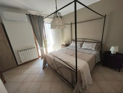 a bedroom with a canopy bed and a chandelier at Casa Carini - Villa Vacanze sul Mare con piscina idromassaggio in Carini