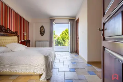 a bedroom with a bed and an open door at Amazing Villa with pool & Jacuzzi in Balestrate