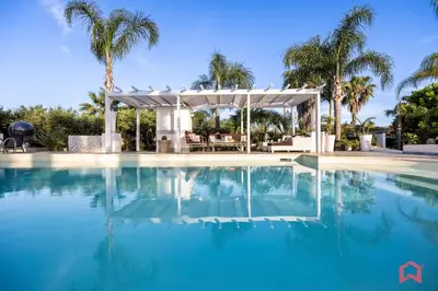 a swimming pool with a gazebo and palm trees at Amazing Villa with pool & Jacuzzi in Balestrate