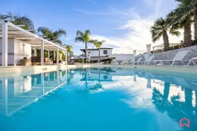 a swimming pool with palm trees and a house at Amazing Villa with pool & Jacuzzi in Balestrate