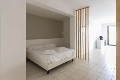 a bedroom with a white bed and a white tile floor at Visitsicilia Vasile 9 in Castellammare del Golfo