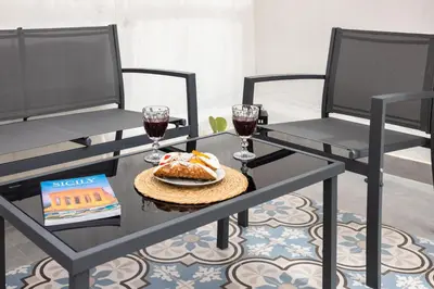 a table with two chairs and a plate of food and wine at Casa Marinù in Palermo