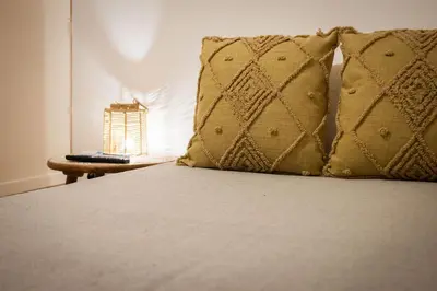 a bed with two pillows and a table with a lamp at Casa Marinù in Palermo