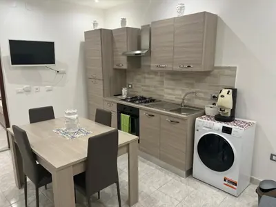 a kitchen with a table and a washing machine at Ginevra House in Palermo