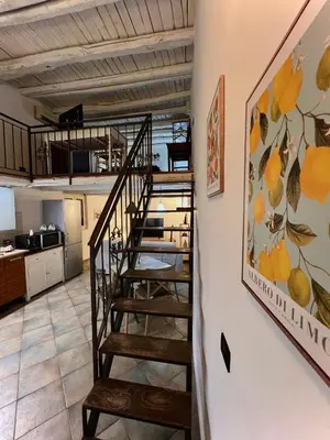 a spiral staircase in a kitchen with a painting on the wall at Sisidda Home in Palermo