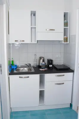 a kitchen with white cabinets and a sink at apartment by the sea Mondello beach in Palermo