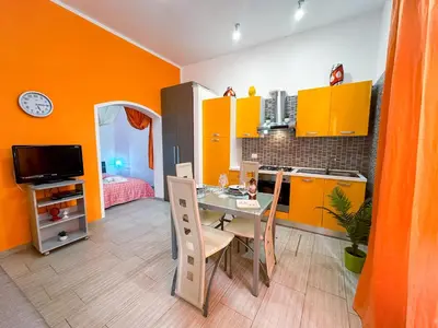 a kitchen with yellow cabinets and a table with chairs at Appartamenti Bellini in Castellammare del Golfo