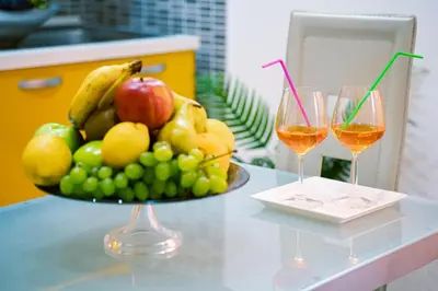 two glasses of wine and a bowl of fruit on a table at Appartamenti Bellini in Castellammare del Golfo