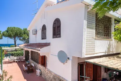 a white building with a porch and a patio at Le Casette all'Addaura by Domus Sicily in Mondello
