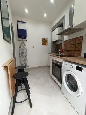 a kitchen with a washing machine and a stool at Glocal flat Maqueda in Palermo