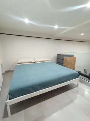a bedroom with a bed and a white wall at Glocal flat Maqueda in Palermo
