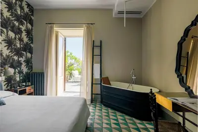 a bedroom with a bed and a tub and a sink at Trinacria Luxury Suite in Palermo