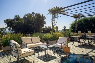 a patio with two chairs and a table and a table and chairs at Trinacria Luxury Suite in Palermo