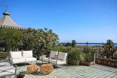 a patio with chairs and a fence and the ocean at Trinacria Luxury Suite in Palermo