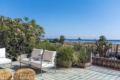 a patio with chairs and a view of the beach at Trinacria Luxury Suite in Palermo