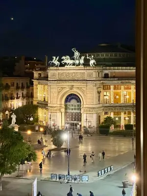 a large building with people in front of it at night at Sabatino Piazza Castelnuovo - Politeama in Palermo