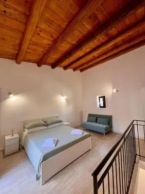 a bedroom with a large bed and a couch at Chicca House in Palermo