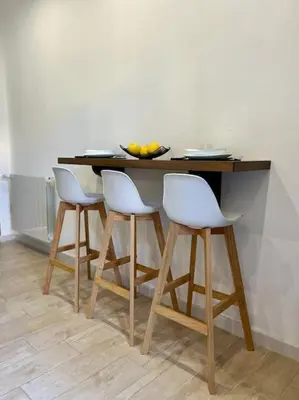 a table with four white chairs and a bowl of fruit at Chicca House in Palermo