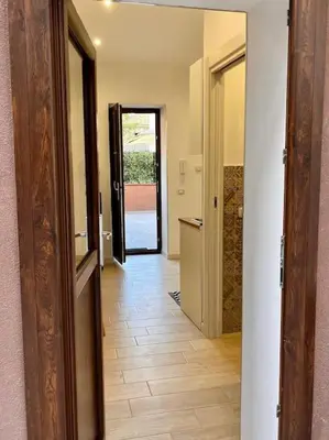 a hallway with an open door to a room with a kitchen at Chicca House in Palermo