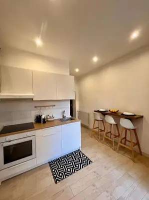 a kitchen with white cabinets and bar stools at Chicca House in Palermo