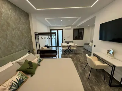 a large living room with a couch and a tv at GRA' Suite Deluxe in Terrasini