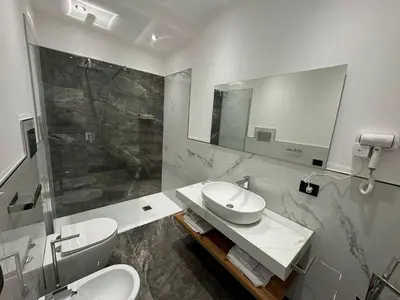 a bathroom with a sink and a toilet and a shower at GRA' Suite Deluxe in Terrasini