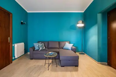 a living room with a couch and a blue wall at Vista San Domenico in Palermo