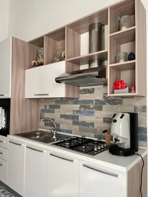 a kitchen with white cabinets and a stove top oven at Azzurra in Terrasini